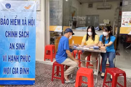 Nhân viên bảo hiểm xã hội tư vấn về chính sách bảo hiểm xã hội, bảo hiểm y tế cho người dân. (Ảnh: TTXVN/Vietnam+)