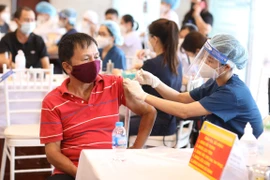 Nhân viên y tế tiêm vaccine phòng COVID-19 cho người dân quận Hoàn Kiếm, chiều 15/9/2021. (Ảnh: Minh Quyết/TTXVN)