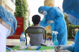 Nhân viên y tế lấy mẫu xét nghiệm cho người dân. (Ảnh: Hoàng Hùng/TTXVN)