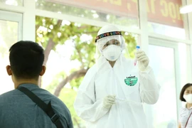 Lấy mẫu xét nghiệm bệnh COVID-19 cho người dân. (Ảnh: TTXVN)
