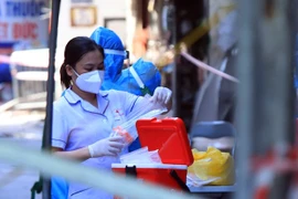 Nhân viên y tế làm công tác lấy mẫu xét nghiệm. (Ảnh: TTXVN/Vietnam+)