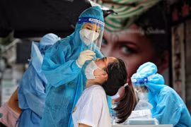 Nhân viên y tế lấy mẫu xét nghiệm cho người dân. (Ảnh: TTXVN)