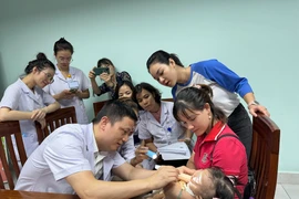 Bác sỹ Bệnh viện Nhi Trung ương khám cho trẻ bị dị tật khe hở môi-vòm miệng. (Ảnh: T.G/Vietnam+)