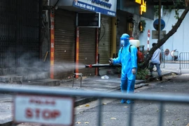 Nhân viên y tế làm công tác phun khử khuẩn. (Ảnh: TTXVN/Vietnam+)