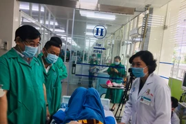 Đoàn chuyên gia của Bộ Y tế vào thăm bệnh nhân 91. (Ảnh: Lê Hảo/Vietnam+)