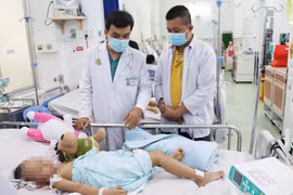 Bác sỹ Bệnh viện Nhi đồng 2 điều trị cho trẻ mắc bệnh tay chân miệng. (Ảnh: TTXVN phát)
