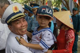Chuẩn đô đốc Phạm Văn Hùng - Phó Tham mưu trưởng Quân chủng hải quân thăm hỏi sức khỏe một cháu bé trên đảo Trường Sa. (Ảnh: Tuấn Anh/Vietnam+)