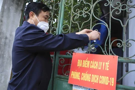 Tổ COVID-19 cộng đồng tới nhà bệnh nhân mắc COVID-19 điều trị tại nhà. (Ảnh: Hoàng Hùng/TTXVN)