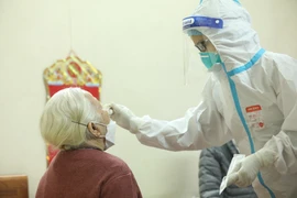 Nhân viên y tế lấy mẫu xét nghiệm cho người dân. (Ảnh: TTXVN/Vietnam+)