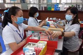 Nhân viên y tế chuẩn bị thuốc để cấp cho bệnh nhân điều trị ngoại trú có tham gia bảo hiểm y tế. (Ảnh: Xuân Triệu/TTXVN)