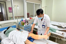 Bác sỹ chăm sóc cho bệnh nhân sau phẫu thuật. (Ảnh: PV/Vietnam+)