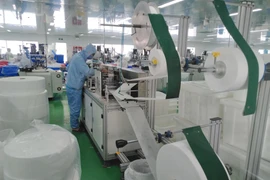 Dây chuyền sản xuất khẩu trang y tế của một công ty. (Ảnh: Minh Hưng/TTXVN)