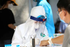 Nhân viên Y tế lấy mẫu máu test nhanh cho các công dân trở về từ Đà Nẵng. (Ảnh: Thành Đạt/TTXVN)