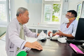 Nhân viên y tế tư vấn sức khoẻ cho người dân đến khám tại Trạm Y tế xã Cam Chính, huyện Cam Lộ, tỉnh Quảng Trị. (Ảnh: T.G/Vietnam+)