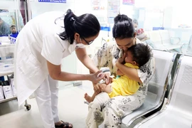 Nhân viên y tế tiêm vaccine phòng bệnh cho trẻ. (Ảnh: TTXVN/Vietnam+)