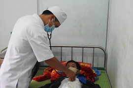 Các bác sỹ tại Trung tâm Y tế huyện Đăk Tô, tỉnh Kon Tum thăm, khám cho bệnh nhân mắc bệnh bạch hầu. (Ảnh: Dư Toán/TTXVN)