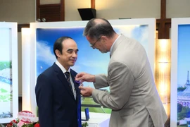 Ngài Olivier Brochet - Đại sứ Cộng hòa Pháp thay mặt Chính phủ Pháp trao tặng cho Giáo sư Nguyễn Hữu Tú - Hiệu trưởng Trường Đại học Y Hà Nội “Huân chương Cành cọ Hàn lâm.” (Ảnh: PV/Vietnam+)