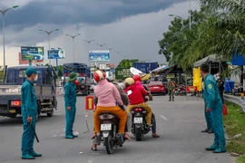 Hướng dẫn người dân đi xe máy về quê. (Ảnh: Thanh Liêm/TTXVN)
