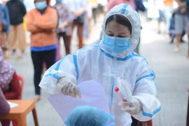Nhân viên y tế lấy mẫu xét nghiệm COVID-19. (Ảnh: TTXVN/Vietnam+)