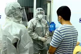 Nhân viên y tế thực hiện các biện pháp nghiệp vụ với bệnh nhân nghi mắc nCoV. (Ảnh: Thành Chung/TTXVN)
