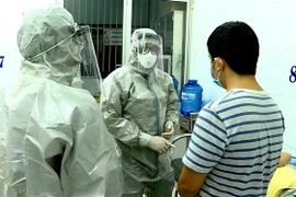 Nhân viên y tế thực hiện các biện pháp nghiệp vụ với bệnh nhân nghi mắc nCoV. (Ảnh: Thành Chung/TTXVN)
