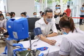 Theo dõi tình hình sức khỏe của người dân trước khi tiêm vaccine COVID-19. (Ảnh: PV/Vietnam+)