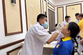 Nhân viên y tế xét nghiệm COVID-19 cho người dân. (Ảnh: Thùy Giang/Vietnam+)