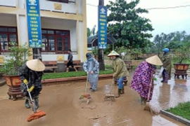 Người dân tham gia dọn dẹp vệ sinh khắc phục hậu quả sau mưa lũ. (Ảnh: Võ Dung/TTXVN)