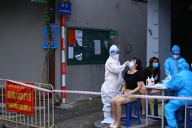 Lực lượng y tế phường Đồng Nhân (Hai Bà Trưng) lấy mẫu xét nghiệm sàng lọc SARs-CoV 2 cho người dân. (Ảnh: Hoàng Hiếu/TTXVN)