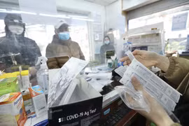 Người dân đi mua que test nhanh tại các hiệu thuốc. (Ảnh: TTXVN/Vietnam+)