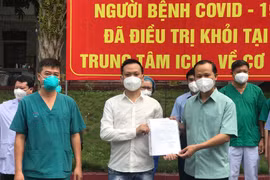 Bác sỹ Trần Thanh Linh và ông Mai Sơn - Phó Chủ tịch tỉnh Bắc Giang trao công bố khỏi bệnh cho bệnh nhân N.V.G. (Ảnh: PV/Vietnam+)