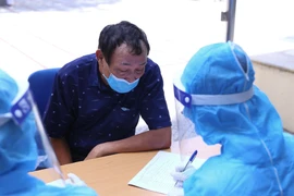 Người dân trên địa bàn Trại Găng được lấy thông tin cá nhân trước khi làm xét nghiệm. (Ảnh: Hoàng Hiếu/TTXVN) 
