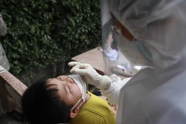 Nhân viên y tế tổ chức lấy mẫu test nhanh cho người dân. (Ảnh: Nguyễn Thảo/TTXVN)
