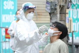 Nhân viên y tế lấy mẫu xét nghiệm cho người dân. (Ảnh: Minh Quyết/TTXVN)