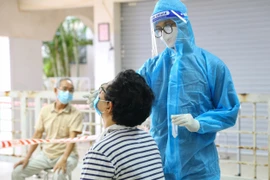 Nhân viên y tế lấy mẫu xét nghiệm. (Ảnh: PV/Vietnam+)