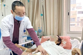 Bác sỹ khám cho bệnh nhân sau phẫu thuật. (Ảnh: PV/Vietnam+)