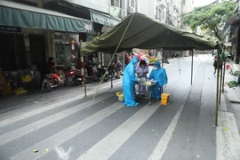 Nhân viên y tế quận Hoàn Kiếm lấy mẫu xét nghiệm COVID-19 cho các trường hợp có nguy cơ cao. (Ảnh: Minh Quyết/TTXVN)