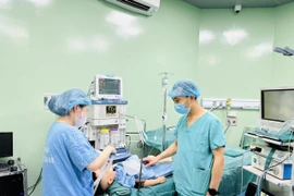 Các bác sĩ thực hiện ca phẫu thuật cho một bệnh nhi. (Ảnh: Bích Huệ/TTXVN)