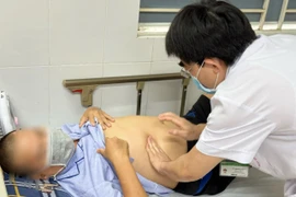 Bác sĩ Điền thăm khám cho nam bệnh nhân. (Ảnh: PV/Vietnam+)