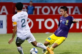 Hà Nội T&T (áo vàng) bất lực trước hàng thủ được chỉ huy bởi trung vệ kỳ cựu Chí Công của XSKT Cần Thơ. (Ảnh: Minh Chiến/Vietnam+)