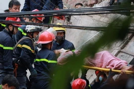 Vào hồi 8 giờ, các lực lượng chức năng vừa giải cứu được thêm một nạn nhân nữ. (Ảnh: Minh Sơn/Vietnam+)