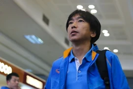 Chiến lược gia người Nhật Bản đầu trần, bước thật nhanh, bỏ lại các học trò ở phía sau, tiến thẳng vào màn mưa, tự xếp đồ, tự ra xe. Không có ai chào đón ông ở Nội Bài. (Ảnh: Minh Chiến/Vietnam+)