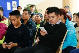 Người đàn ông này vừa ngủ gật trong lúc chờ tới lượt nộp công văn mua vé xem bán kết AFF Cup 2016 Việt Nam - Indonesia. (Ảnh: Minh Chiến/Vietnam+)