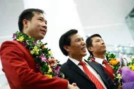 Bộ trưởng Nguyễn Ngọc Thiện (giữa) bên cạnh người hùng bắn súng Việt Nam Hoàng Xuân Vinh. (Ảnh: Minh Chiến/Vietnam+)