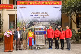 Đại diện Báo VietnamPlus trao tặng bồn chứa nước cho người dân thôn Sính Lủng. (Ảnh: Lê Minh Sơn/Vietnam+)