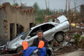 Người dân Trung Quốc dọn dẹp đống đổ nát sau mưa bão tại khu vực Funing, Diêm Thành, tỉnh Giang Tô ngày 24/6. (Nguồn: AFP/TTXVN)