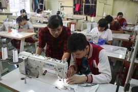 Các em khuyết tật học nghề may tại một trung tâm. (Ảnh: Hồ Cầu/TTXVN)