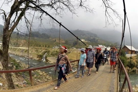 Khách du lịch quốc tế được các hướng dân viên người bản địa đưa đi thăm quan điểm du lịch văn hóa cộng đồng xã Lao Chải-Tả Van. (Ảnh: Thanh Hà/TTXVN)