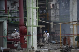 Các công nhân tìm kiếm nạn nhân mất tích trong vụ nổ tại nhà máy hóa dầu Pajaritos. (Nguồn: AFP/TTXVN)