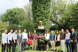 Cán bộ Đại sứ quán Việt Nam dâng hoa lên Bác nhân 126 năm Ngày sinh của Người. (Ảnh: Việt Hòa-Việt Hùng/Vietnam+)